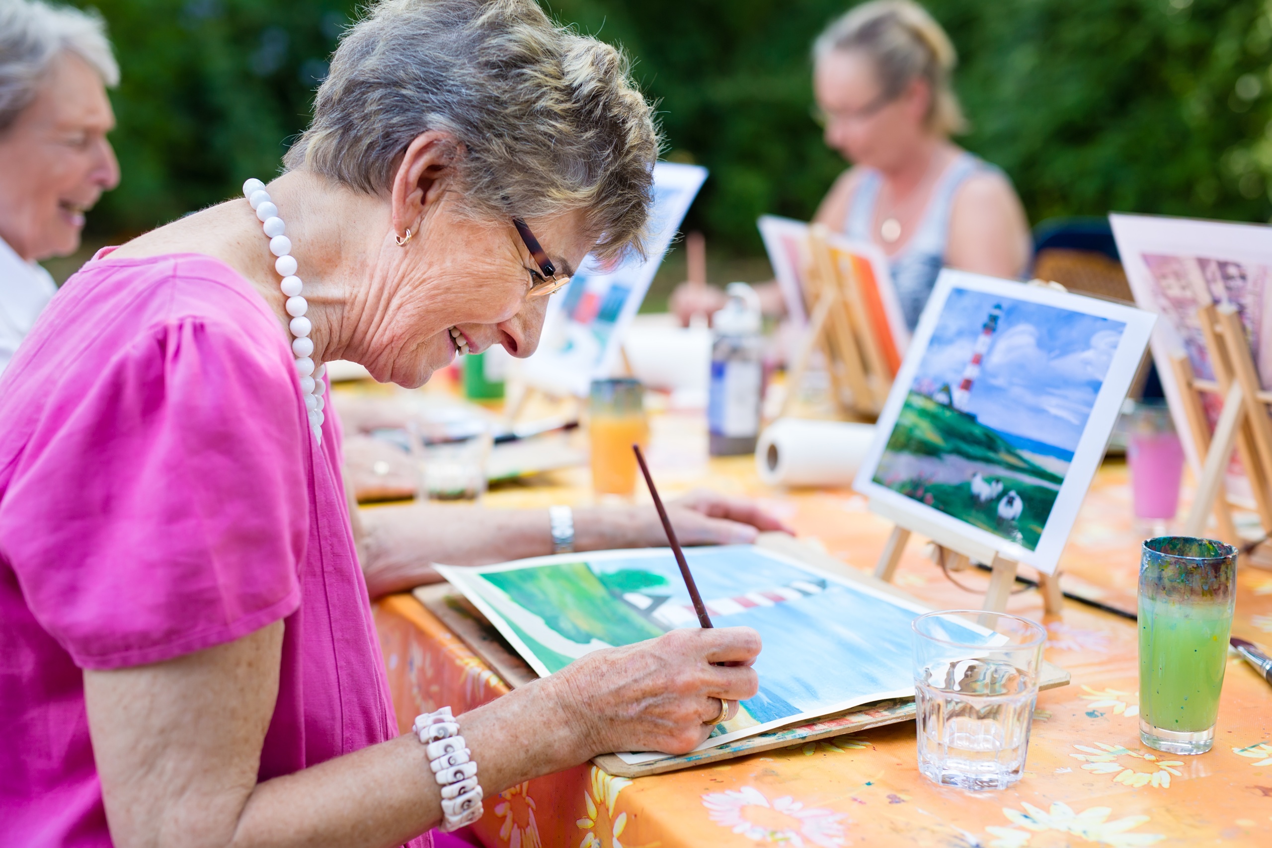 Senior woman participating in painting hobby.